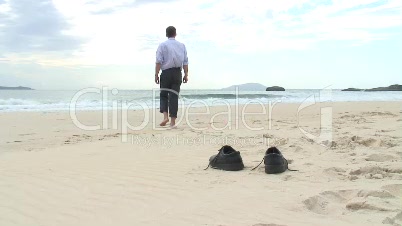 Manager geht barfuß am Strand