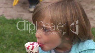 Kleiner Junge isst ein Eis und schauekelt dabei