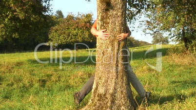 Paar küsst sich hinter einem Baum