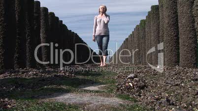 Blonde junge Frau spaziert am Strand