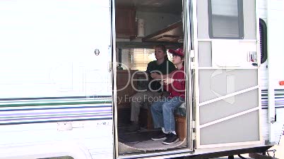 Two people playing video games inside an R.V. Trailer