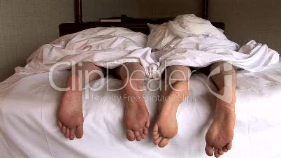 Feet of Couple in Bed