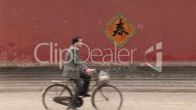 Bike Riding past a Red Wall