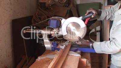 Malawi: african worker cuts wood with electric saw
