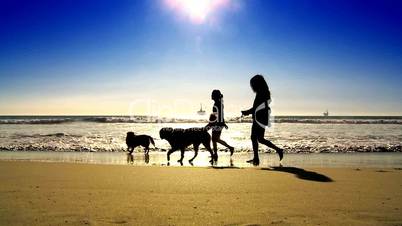 Frauen mit Hunden am Sandstrand