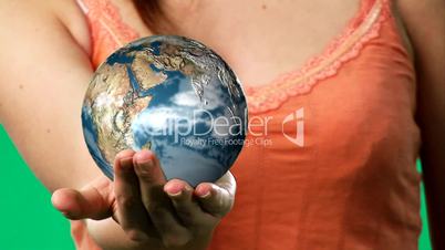 Chroma key footage of a woman holding a globe