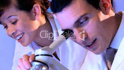 Ärztin und Arzt schauen durch ein Mikroskop