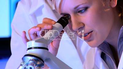 Zwei Ärztinnen untersuchen mit Hilfe eines Mikroskops