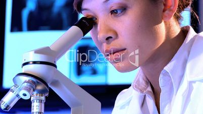 Nahaufnahme - Ärztin schaut durch ein Mikroskop