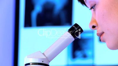 Nahaufnahme - Ärztin schaut durch ein Mikroskop