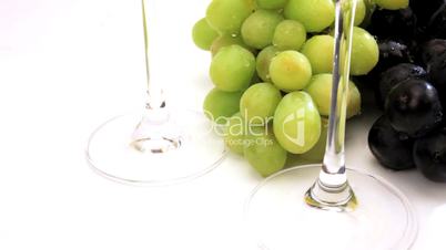 Grüne und blaue Trauben neben Weingläsern