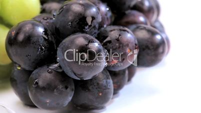 Nahaufnahme - Blaue und grüne Trauben neben Weingläsern