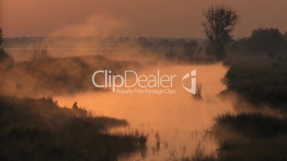 Fisherman. Morning on the foggy lake.