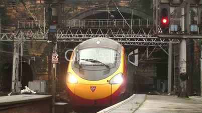 Virgin Pendolino train coming out of a tunnel into station