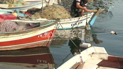 Small fishing boat sails into harbor to unload his catch