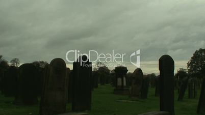 Time-lapse clip of gravestones silhouetted against a stormy sky