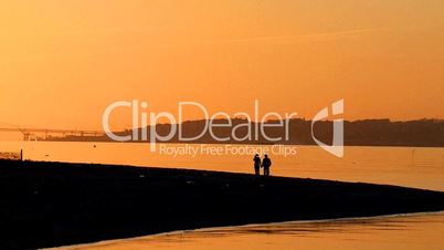 Couple walking on beach at sunset