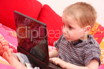 kleiner junge am laptop