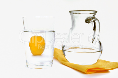 Wasser im Glaskrug neben Glas und Zitrone