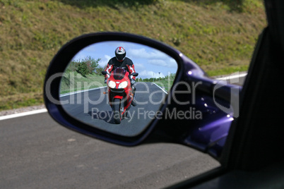 Motorradfahrer im Rückspiegel