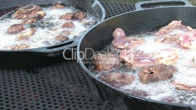 Fritierendes Hammelfleisch in zwei Pfannen