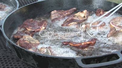 Fritierendes Hammelfleisch wird gewendet