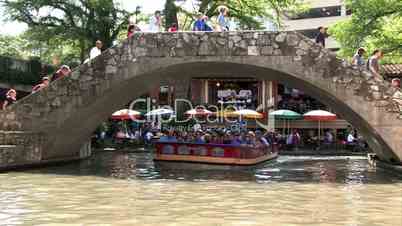 Sightseeing Boot mit Touristen unter einer Brücke