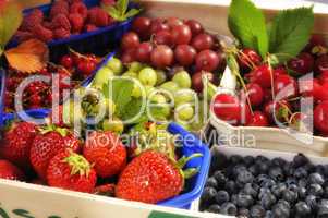 Kiste mit frischen Beeren und Kirschen