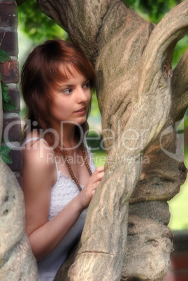 junge Frau blickt durch Baumgabelung