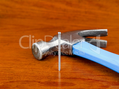 Hammer and nail on wooden background