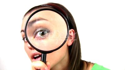 Curious woman looking through a magnifying glass