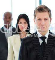 Portrait of a serious businessman in front of his team