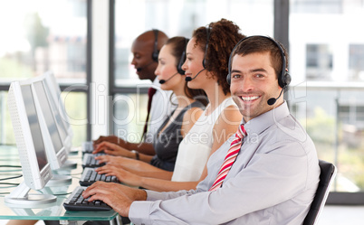 Smiling businessman working in a call center