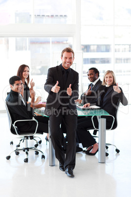 Businessman with thumbs up in a meeting