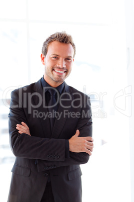 Handsome smiling businessman with folded arms