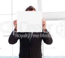 Businessman holding a white card in front of his face