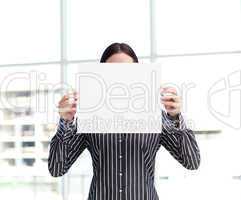 Smiling woman showing a big business card in front of her face