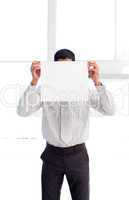 Businessman showing a white card in front of his face