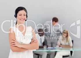Businesswoman talking on a headset with folded arms