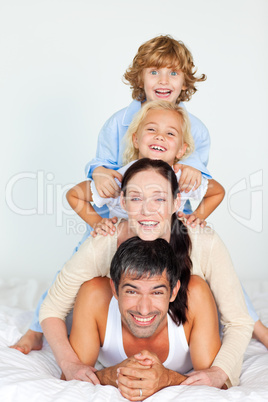 Parents and children playing in bed