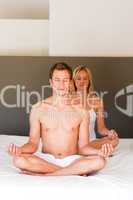 Couple doing exercises on bed with copy-space