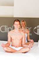 Smiling woman doing yoga on bed