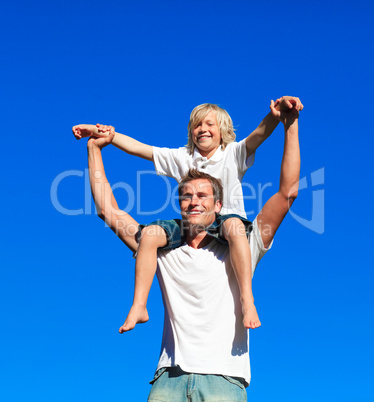 Child sitting on his father's shoulders
