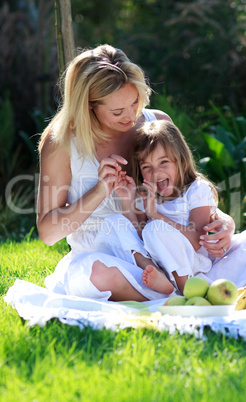 Mother and daughter having fun in a picnic