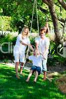 Happy familiy having fun swinging