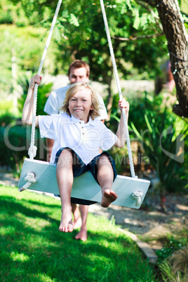 Dad and kid having fun swinging together