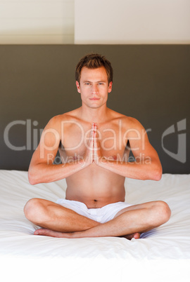 Young boy doing exercises on bed
