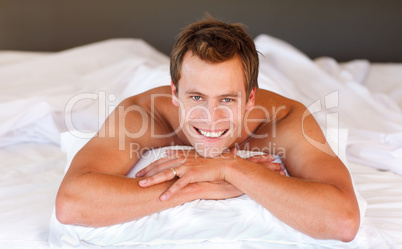 Attractive man smiling on bed