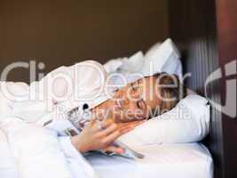 Young woman reading a magazine in bed