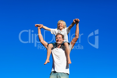 Kid sitting on his father's shoulders